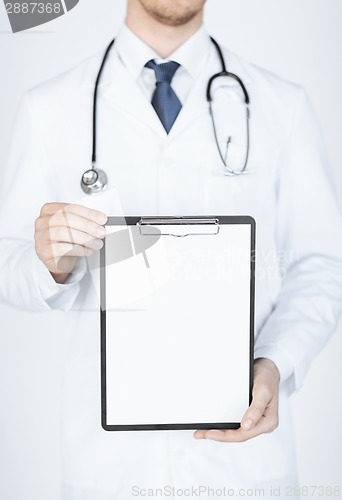 Image of doctor holding blank white paper