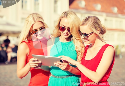 Image of beautiful girls toursits looking into tablet pc