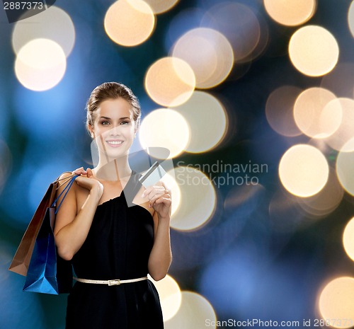Image of smiling woman with shopping bags and credit card