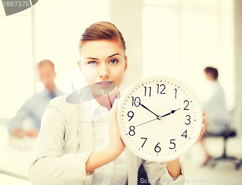 Image of businesswoman showing white clock in office