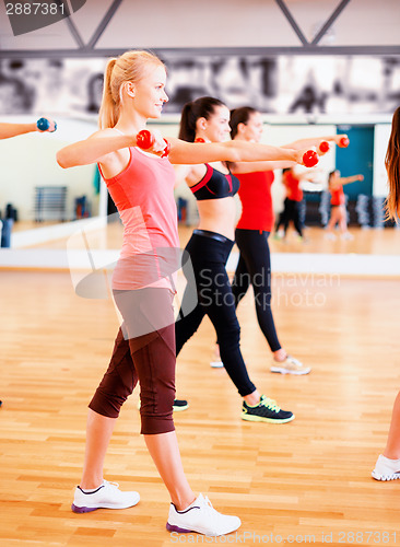 Image of group of smiling people working out with dumbbells
