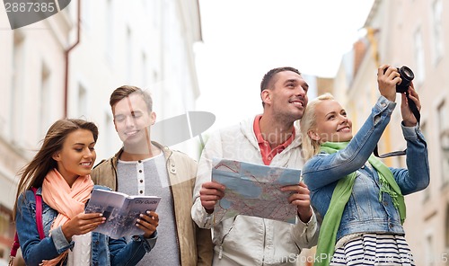 Image of group of friends with city guide, map and camera