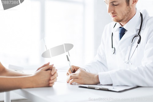 Image of patient and doctor taking notes