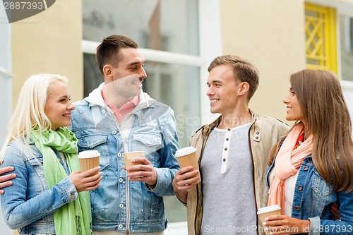 Image of group of smiling friends with take away coffee