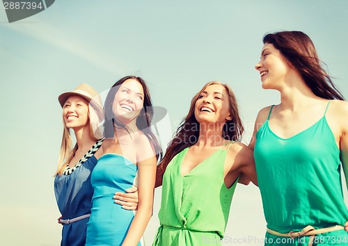 Image of smiling girls walking on the beach