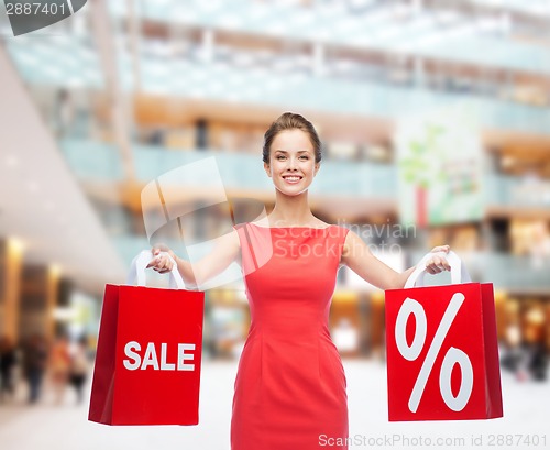 Image of young woman in red dress with shopping bags