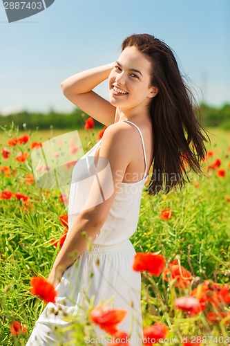 Image of smiling young woman on poppy field