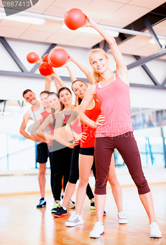 Image of group of smiling people working out with ball