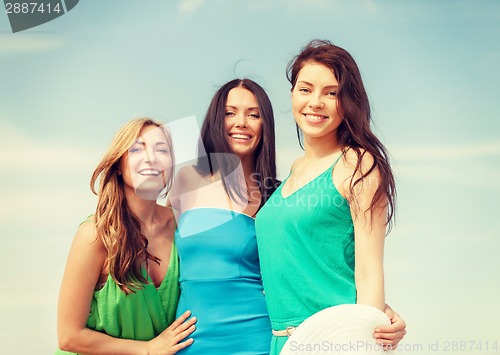 Image of smiling girls walking on the beach