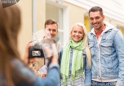 Image of group of smiling friends taking photo outdoors