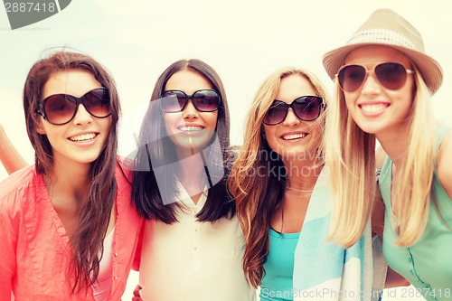 Image of girls in shades having fun on the beach