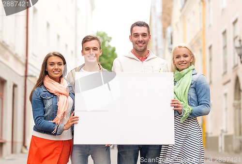 Image of group of smiling friends with blank white board