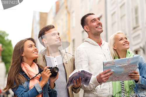 Image of group of friends with city guide, map and camera