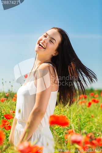 Image of laughing young woman on poppy field
