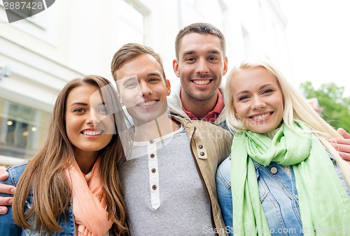 Image of group of smiling friends in city