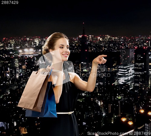 Image of smiling woman in dress with shopping bags