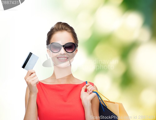 Image of smiling woman with shopping bags and plastic card