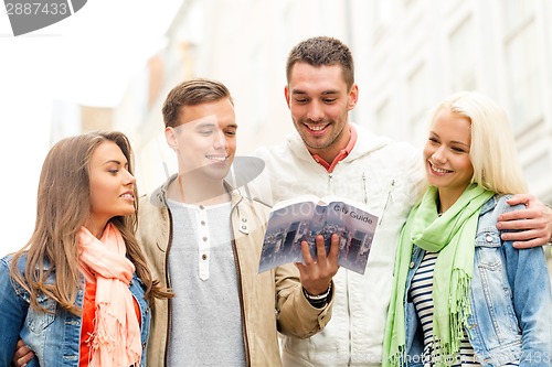 Image of group of friends with city guide exploring town