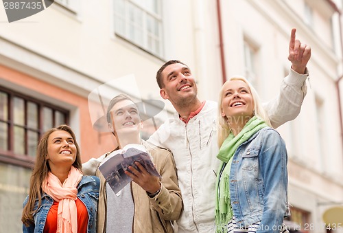 Image of group of friends with city guide exploring town