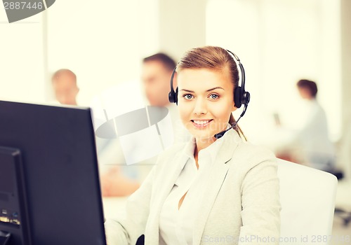 Image of helpline operator with headphones in call centre