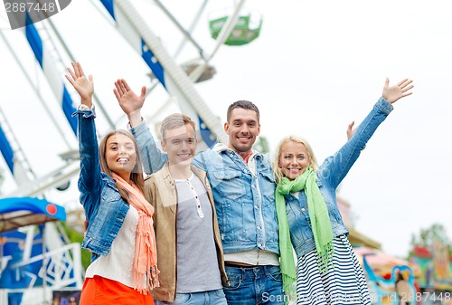 Image of group of smiling friends waving hands