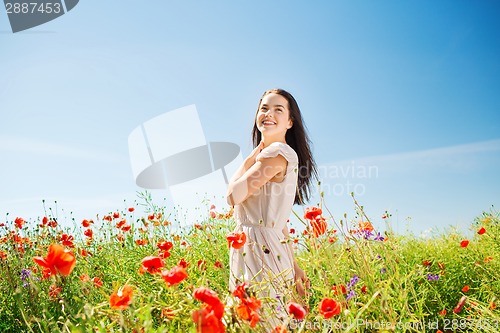 Image of smiling young woman on poppy field