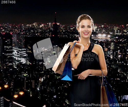 Image of smiling woman in dress with shopping bags