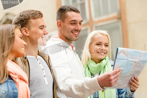 Image of group of friends with map exploring city