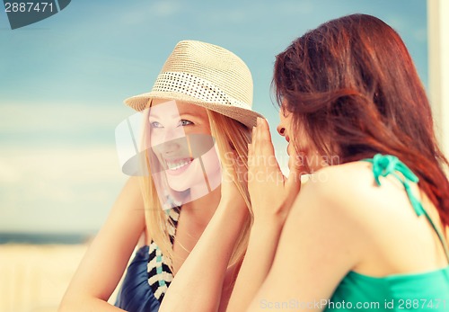 Image of girls gossiping in cafe on the beach