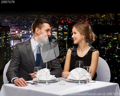 Image of smiling couple looking at each other at restaurant