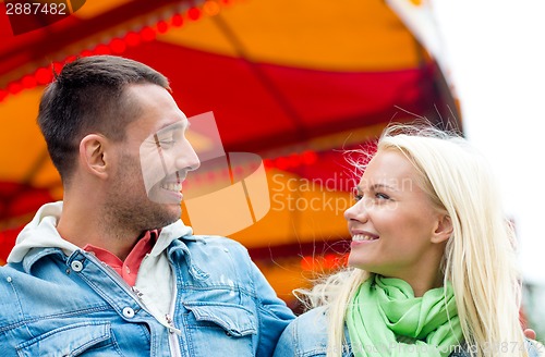 Image of smiling couple in amusement park