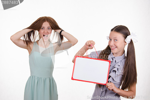 Image of Teacher in horror, student with a sign