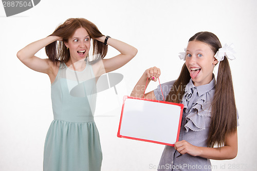 Image of Teacher in horror looking at the student with a sign