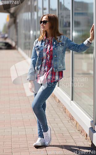 Image of Young beautiful stylish girl in sunglasses on the streets