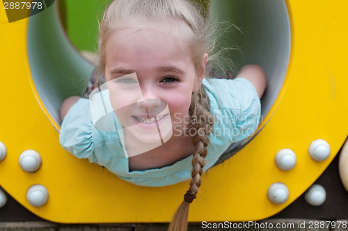 Image of Adorable young girl sitting in crawl tube