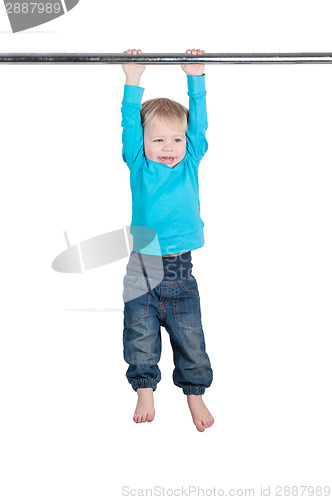 Image of Portrait of a little boy hangs by horizontal bar