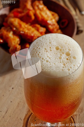 Image of glass of fresh beer and fried chicken wings