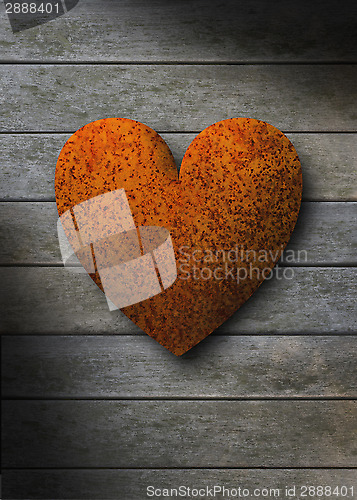 Image of Rusty metal heart against gray weathered wood planks