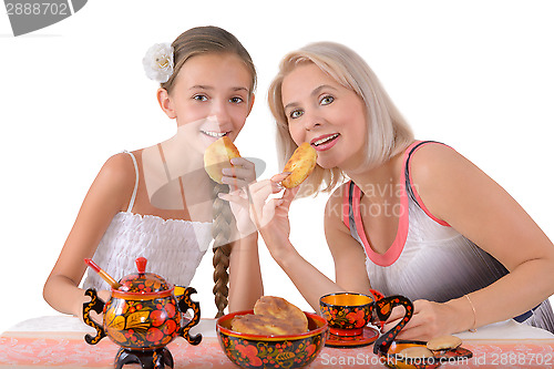 Image of Mother and daughter eating pies