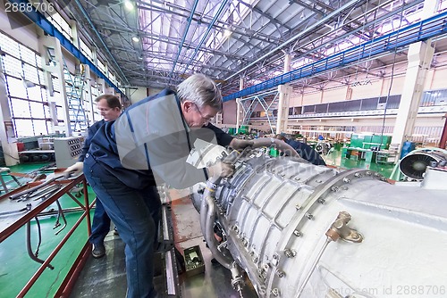 Image of Mechanics work over assembly of aviation engine