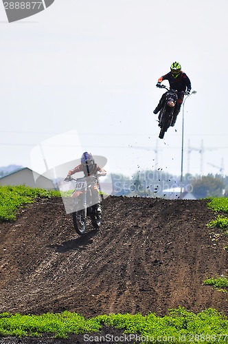 Image of Motorcyclists on motorcycles participate in cross-country race.