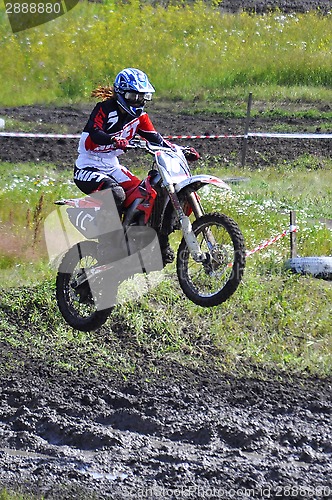 Image of The girl motorcyclist on the motorcycle carries out a jump.