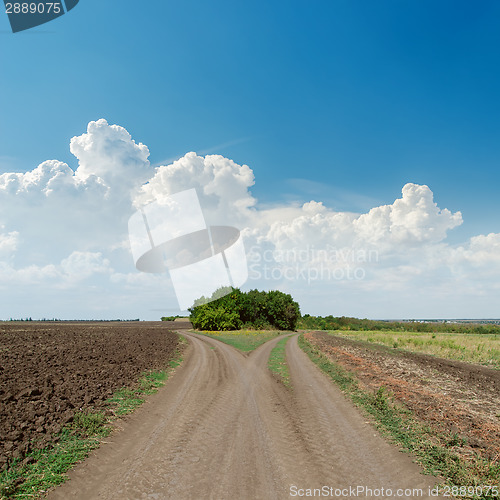 Image of two rural roads to horizon and clouds in blue sky