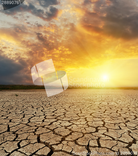 Image of cracked desert closeup and dramatic sunset over it