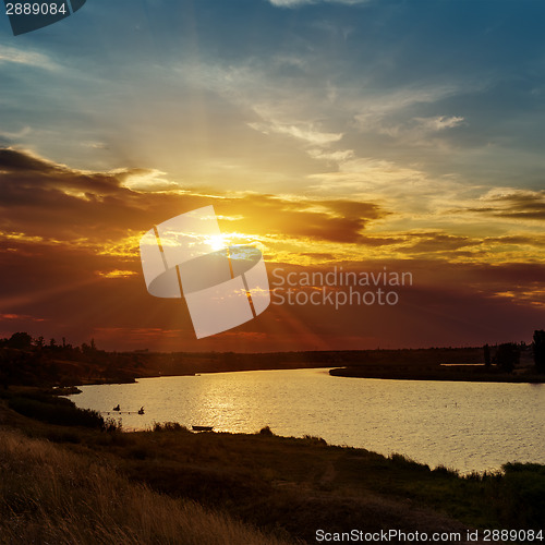 Image of dramatic orange sunset and river