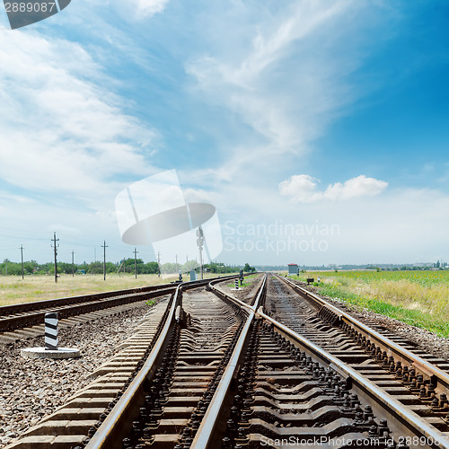 Image of crossing of railroad under cloudy sky