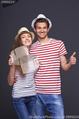 Image of Young casual couple giving thumbs up