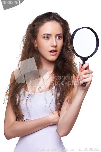 Image of Surprised woman looking through the magnifying glass