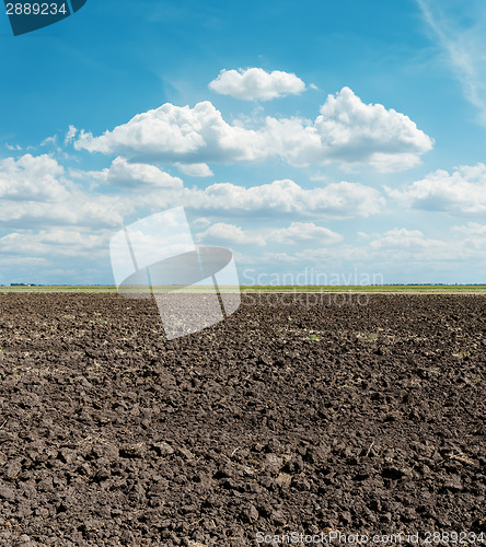 Image of black arable field after harvesting and blue sky