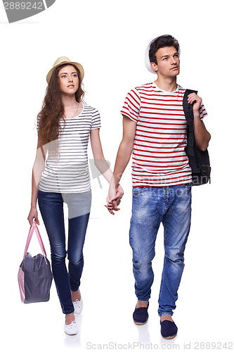 Image of Young couple walking with travel bags